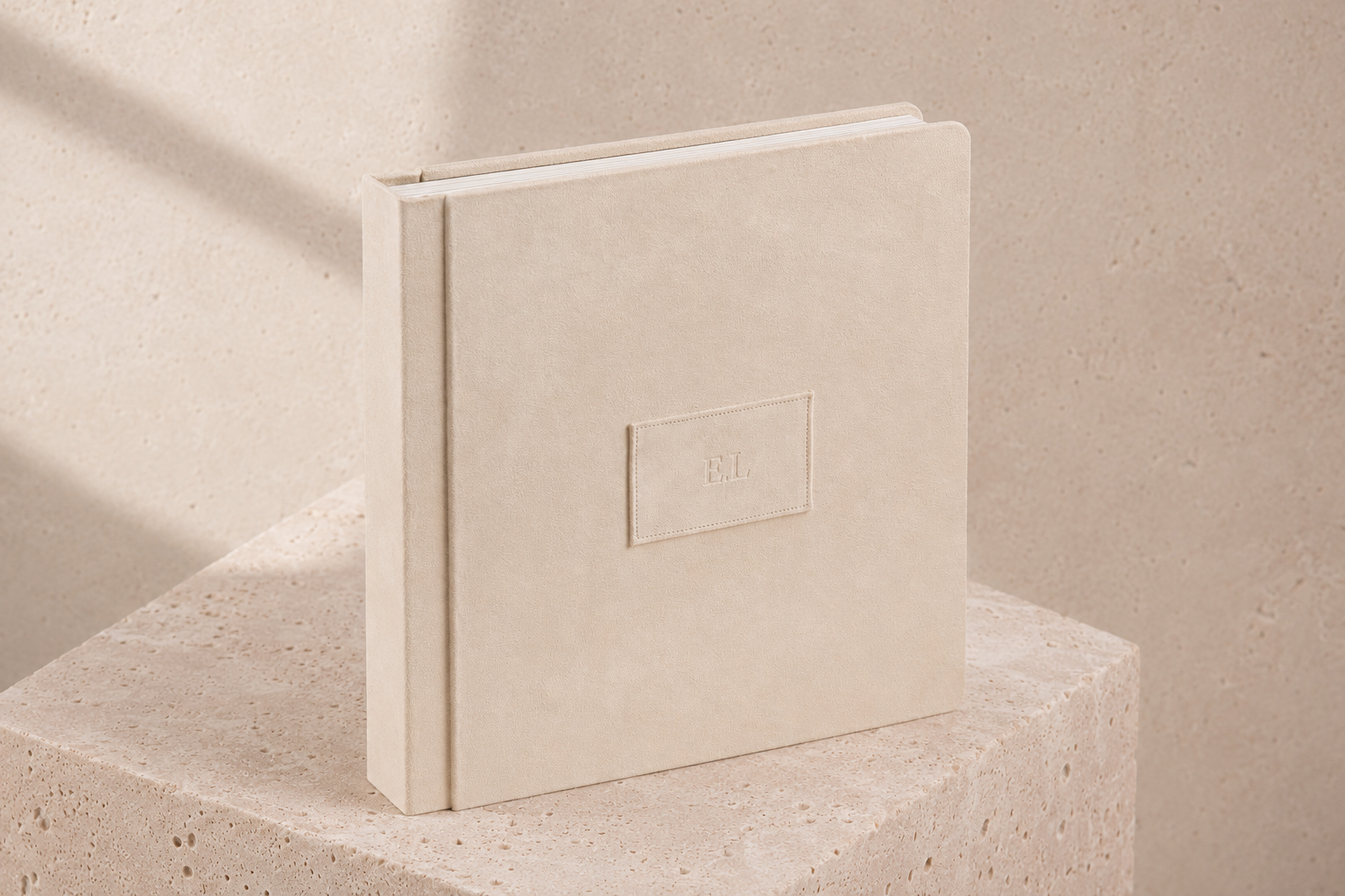 E.L. suede album styled on a travertine pedestal