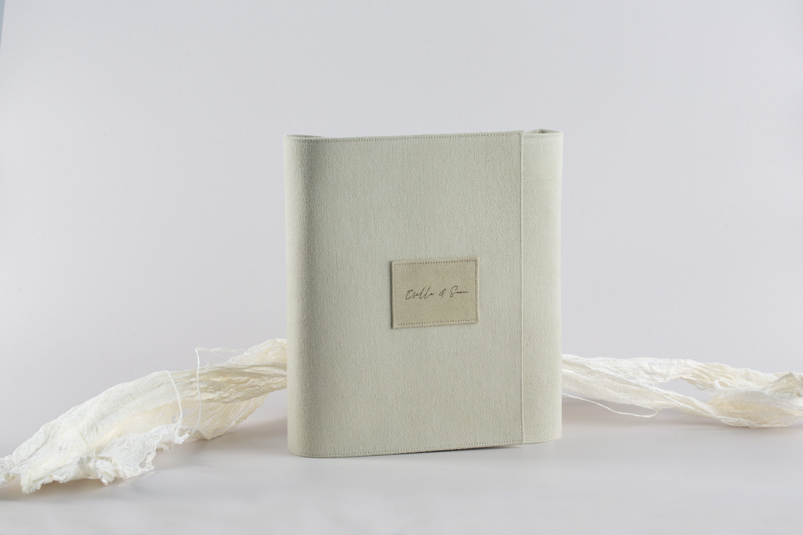 Pale textile-covered Tramontina Collection volume standing on a light background with a stitched name patch